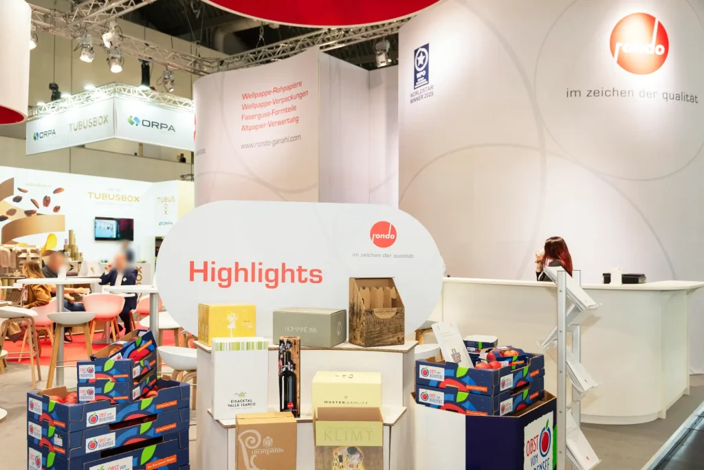 Gesamtansicht des Rondo Ganahl Messestands auf der FachPack 2025 mit rotem Design und nachhaltigen Verpackungslösungen – Messebau Nürnberg.