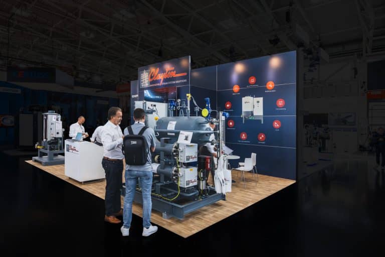 Fachbesucher am Clayton Messestand auf der Drinktec 2025 in München mit Hochleistungs-Dampfgeneratoren und modernem Standdesign – Messebau München.