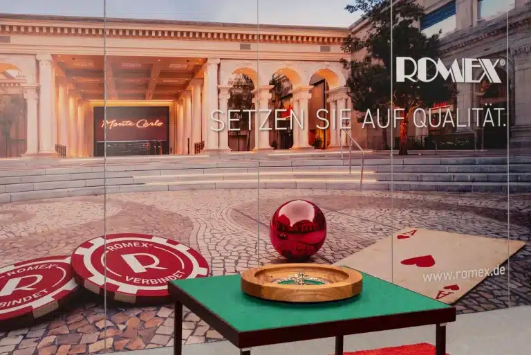 Detail des Romex-Messestands auf der GaLaBau Nürnberg mit roter Kugel, Roulettetisch und großflächiger Bildwand im Casino-Motiv.