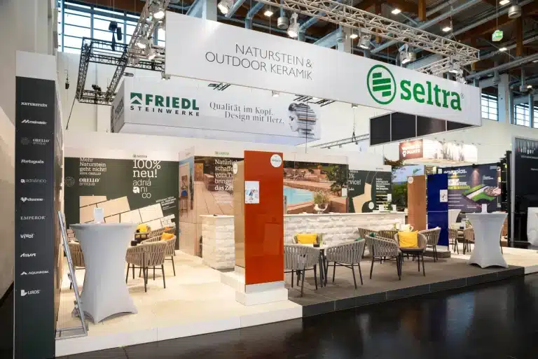 Messebau für seltra auf der GaLaBau Nürnberg mit Blenden von seltra und Friedl Steinwerke, Musterwand und offenen Sitzbereichen.